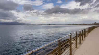 Metal bir korkuluktan gelen panoramik deniz ufku kıyı yürüyüşü, bulutlu gökyüzü. Hava ve doğa, okyanus.