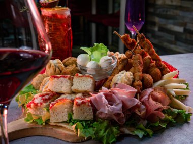 İtalyan aperatifleri ya da parti için aperatifler için tepside bir tabak tuzlu atıştırmalık yakın çekim. Konsept partiler ve yemek ve yemek ile kutlamalar