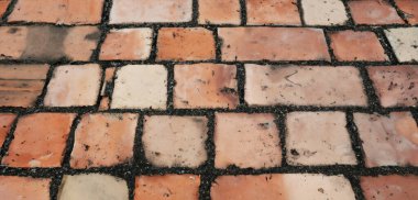 Kahverengi dikdörtgen taşlardan yapılmış eski bir cadde yolu yüzeyindeki kaldırım taşlarını kapatın. Eski yol granit taşları 3 boyutlu.