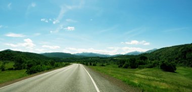Kırsalda uzun bir yol var. Yolun iki yakası da ağaçlar ve doğa ile dolu. Tatillerde uzun yolculuklar.