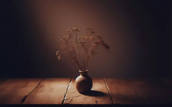 Dried flowers in a cracked vase On an old wooden table and the sunlight shining through it in the evening A quiet room in brown tones Background image