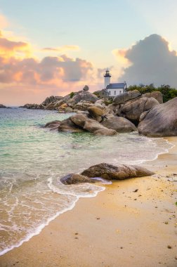 Britanya 'nın kuzeyindeki Finistere' de kayalık bir noktada bulunan Pontusval deniz feneri, gün doğumunda şeffaf turkuaz sulara bakıyor..