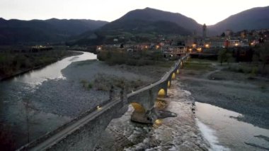 Gün batımında Gobbo Köprüsü üzerinden Trebbia nehri üzerinde Bobbio, Emilia Romagna, İtalya.