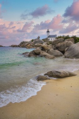 Britanya 'nın kuzeyindeki Finistere' de kayalık bir noktada bulunan Pontusval deniz feneri, gün doğumunda şeffaf turkuaz sulara bakıyor..