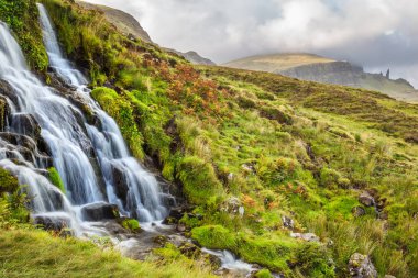 Altın ışık ve canlı, renkli gün batımı ya da İskoçya 'nın Skye Adası' ndaki Gelin Şelalesi 'nde, Fırtınalı Yaşlı Adam' ın dramatik manzarası üzerinde gün doğumu gökyüzü.. 