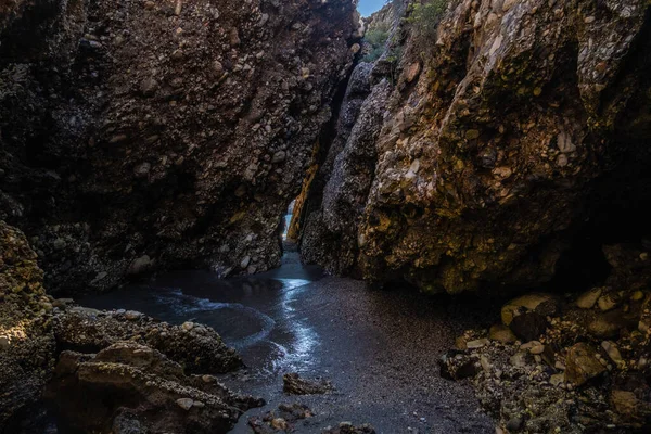 Beautiful view of secret path between rocks in Nerja beach, Spain.