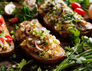 Çırpılmış yumurta, kızarmış kırmızı soğan halkaları ve tahtadan taze soğan.