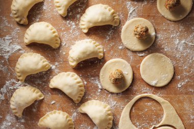 Tahta arka planda çeşitli hazırlık safhalarında çiğ hamur tatlısı. Geleneksel yemek