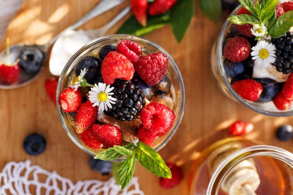 Healthy dessert or breakfast made of natural greek yoghurt, honey, fresh blueberries, raspberries and strawberries, top view