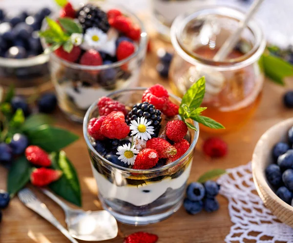 Healthy dessert or breakfast made of natural greek yoghurt, honey, fresh blueberries, raspberries and strawberries, close up view