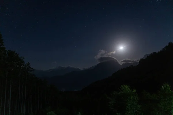 Night sky background. Moon above the mountains. Moon and stars nature background. High quality photo