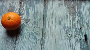 Bir portakal suyu, üç portakal ve bir bardak taze sıkılmış meyve suyunu mavi arka planda yapma süreci.