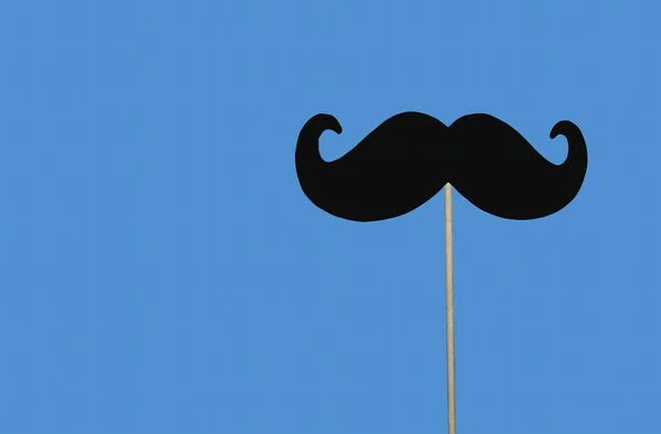 Masa örtüsü üzerine kağıt siyah bıyık, mavi kağıt arka planda. Kes biçimi, Movember konsepti, Üst görünüm, Düz alan, Kopyala