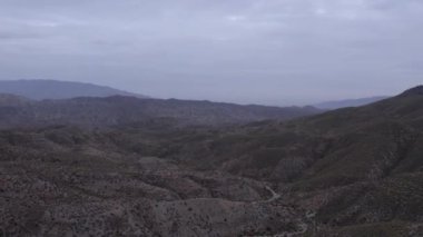 İspanya 'nın güneyindeki Almerya' da Tabernas Çölü, vadileri olan yarı kurak bir dağlık bölge, çalılar var, gökyüzü bulutlu.