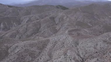 İspanya 'nın güneyindeki Almerya' da Tabernas Çölü, vadileri olan yarı kurak bir dağlık bölge, çalılar var, gökyüzü bulutlu.