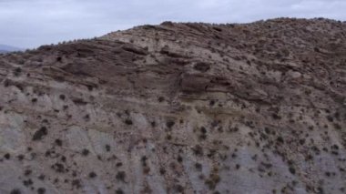 İspanya 'nın güneyindeki Almerya' da Tabernas Çölü, vadileri olan yarı kurak bir dağlık bölge, çalılar var, gökyüzü bulutlu.