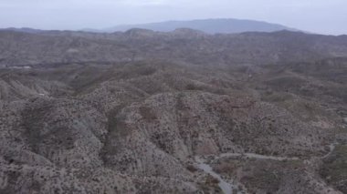 İspanya 'nın güneyindeki Almerya' da Tabernas Çölü, vadileri olan yarı kurak bir dağlık bölge, çalılar var, gökyüzü bulutlu.