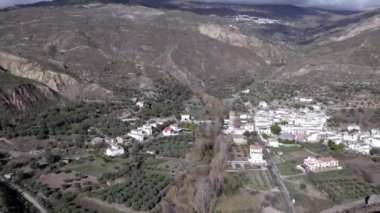 İspanya 'nın güneyindeki küçük Yator kasabası, kasaba bir vadide, ağaçlar ve bitkiler var, bir dağ bölgesi, dağlarda bulutlar var.