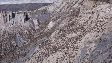 İspanya 'nın güneyinde sarp bir bölgenin havadan çekilmiş videosu, bir çok vadi var, yeryüzünün farklı gölgeleri var, çalılar var, gökyüzü bulutlu.