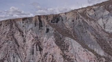 İspanya 'nın güneyinde sarp bir bölgenin havadan çekilmiş videosu, bir çok vadi var, yeryüzünün farklı gölgeleri var, çalılar var, gökyüzü bulutlu.