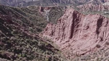 İspanya 'nın güneyinde sarp bir bölgenin havadan çekilmiş videosu, bir çok vadi var, yeryüzünün farklı gölgeleri var, çalılar var, gökyüzü bulutlu.