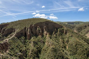 İspanya 'nın güneyindeki sarp arazi, arazi ağır şekilde aşınmış, çalılar var, dağlık bir bölge, gökyüzü bulutlu.