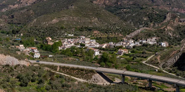 Yator Granada 'nın güneyinde küçük bir kasaba, kasabanın evleri beyaz, bir kilise, bir yol geçidi ve bir köprü var, bir sürü bitki örtüsü var.