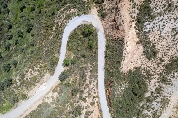 Stock image overhead photo of an old road in the south of Granada, the road is asphalt, there are bushes and trees