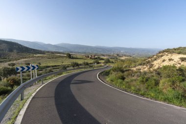 Granada 'nın (İspanya) güneyi karayolu, birkaç trafik ışığı, birkaç zeytin ağacı, harabe halinde bir çiftlik evi, dağlık bir alan, gökyüzü açık.