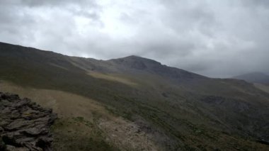 Sierra Nevada dağında bulutlar hareket ediyor, kayalar var ve arazi dik.