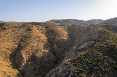 Granada 'nın güneyindeki dağlık alanda çalılar var, birkaç vadi var, gökyüzü açık.