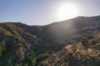 Yator 'un (Granada) yanındaki dağ yamacında, zeytin ve badem ağaçları, çalılar, birkaç vadi var, gökyüzü açık.