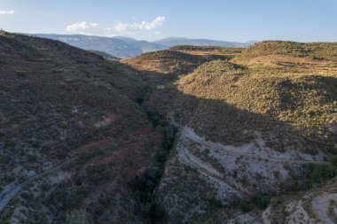 Granada 'nın güneyindeki dağlarda gün batımı, dağda çalılar ve ağaçlar var, gökyüzü açık.