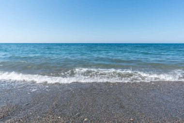 İspanya 'da Akdeniz kıyısında kumsal küçük taşlardan yapılmıştır, gökyüzü açıktır.