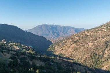 Granada 'nın güneyindeki dağlık bölgede ağaçlar ve çalılar var, gökyüzü açık.