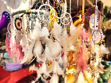 Çeşitli renkte ve tasarımlarda bir düş kapanı sergisi, bir pazarda asılı..