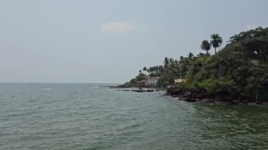 Dona Paula Pier, Dias Sahili Erişimi, Dona Paula, Panaji Paula bakış açısı kayalık kayalıklar, palmiye ağaçları ve sakin sularla dolu güzel bir deniz manzarası, muhtemelen Goa 'da sakin bir kıyı bölgesini resmediyor.