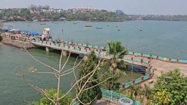 Dona Paula Sahili Köşkü GOA arka planında tekne ve bina manzaralı hareketli bir alana giden canlı bir yaya köprüsü.