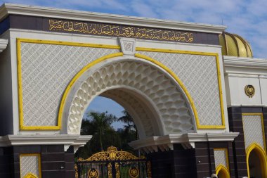Kuala Lumpur 'daki Istana Negara' nın (Ulusal Saray) giriş kapısı. Kemer, üzerinde Arapça kaligrafi ve Malezya kraliyetini temsil eden altın kubbeler bulunan karmaşık beyaz ve altın detaylar içeriyor..