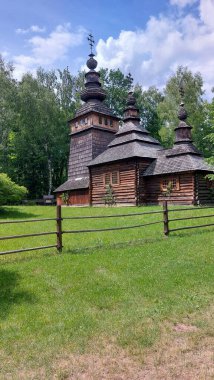 Historic Wooden Orthodox Church with Decorative Crosses in Lush Forest Setting clipart