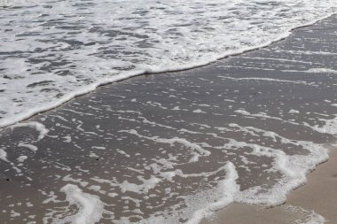 Dalgalar ve Deniz Köpüğü Kum Sahil Hattı 'nda