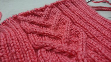 Yakın plan pembe örülmüş kumaş örgülü kablo desenli. El örgüsü dokusunun detaylı fotoğrafçılığı. Tekstil ve baskı için el yapımı tasarım kavramı