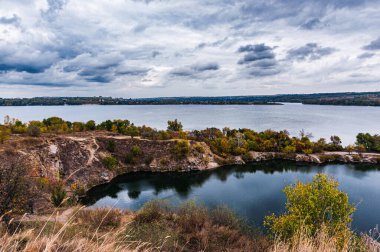 Ukrayna. Bulutlu bir sonbahar günü. Yaşlı Kodax. Granit ocağı suyla doldu. Dnieper River. Bulutlu. Boşluğu kopyala.