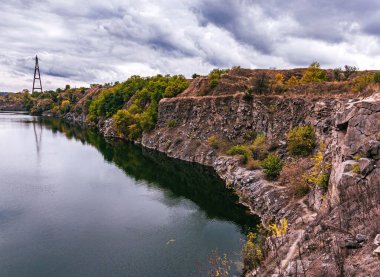 Ukrayna. Bulutlu bir sonbahar günü. Yaşlı Kodak. Granit ocağı suyla dolmuş. Bulutlu gökyüzü. Boşluğu kopyala.