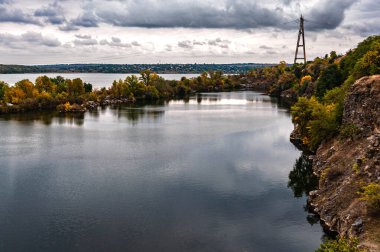 Ukrayna. Bulutlu bir sonbahar günü. Yaşlı Kodak. Granit ocağı suyla dolmuş. Bulutlu gökyüzü. Boşluğu kopyala.