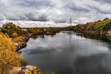 Ukrayna. Bulutlu bir sonbahar günü. Yaşlı Kodak. Granit ocağı suyla dolmuş. Bulutlu gökyüzü. Boşluğu kopyala.