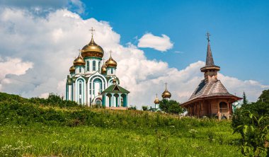 Ukrayna. Beyaz bulutlu mavi gökyüzünün arka planında altın kubbeleri olan bir kilise. Uzayı kopyala..