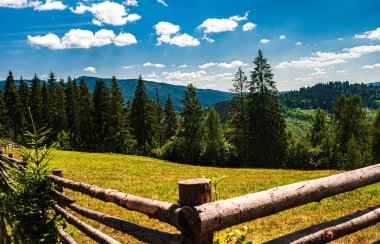 Ukrayna. Karpatlar 'ın görüşü. Karpatlar 'ın üzerinde beyaz bulutlar olan mavi gökyüzü. Arka plan bulanık. Boşluğu kopyala.