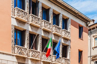 Avrupa. İtalya. Veronika 'da penceresi olan bir ev duvarı. Avrupa Birliği ve İtalya bayrağı..