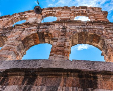 Italy.Verona. Arena di Verona 'nın bir parçası beyaz bulutlu mavi gökyüzünün arka planına karşı. Boşluğu kopyala.